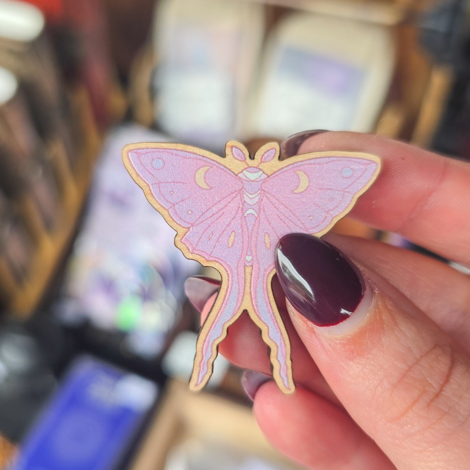 A wooden pink butterfly-shaped pin badge